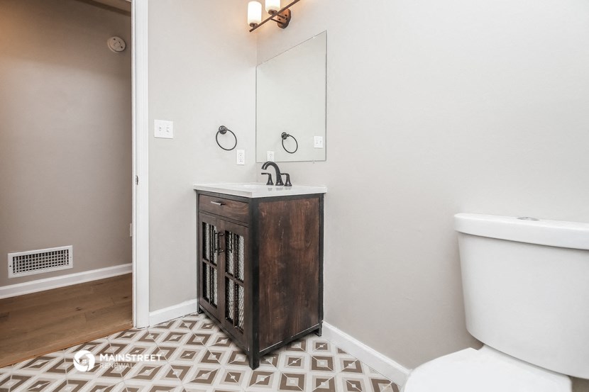 a bathroom with a toilet and a sink and a mirror