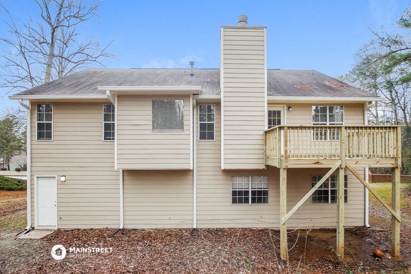 a yellow house with a porch and a deck