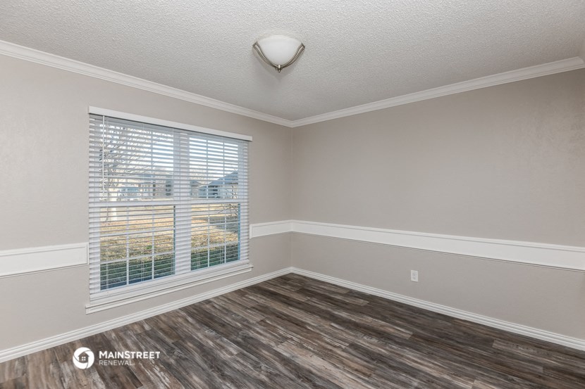 the living room of an empty house with a large window