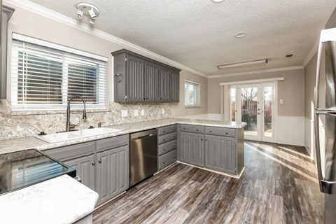 a kitchen with gray cabinets and a sink and a refrigerator