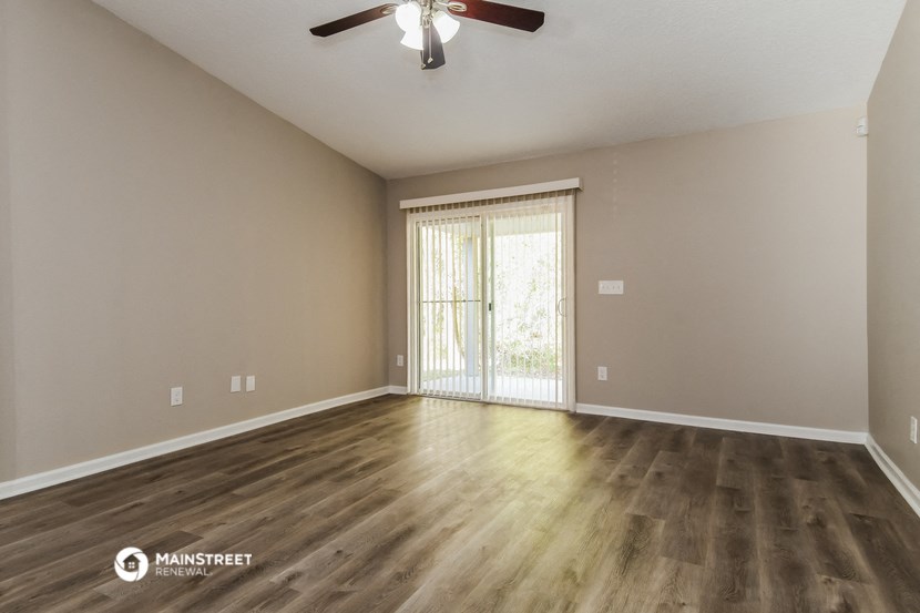 the spacious living room with hardwood flooring and sliding glass door