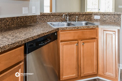 a kitchen with granite counter tops and a stainless steel dishwasher