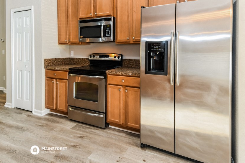 a kitchen with stainless steel appliances and wooden cabinets
