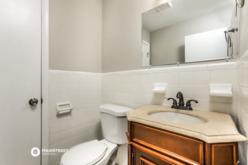 a bathroom with a toilet and a sink and a mirror