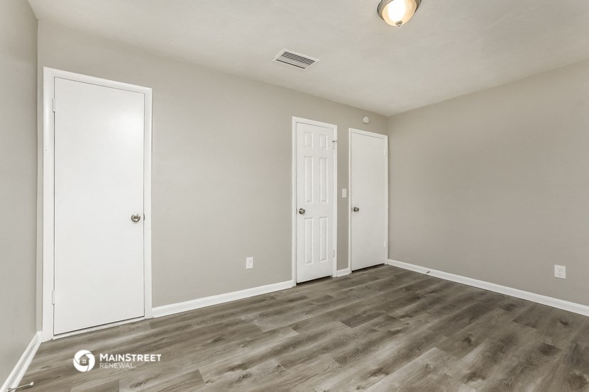 the spacious living room of a new home with white walls and wood flooring