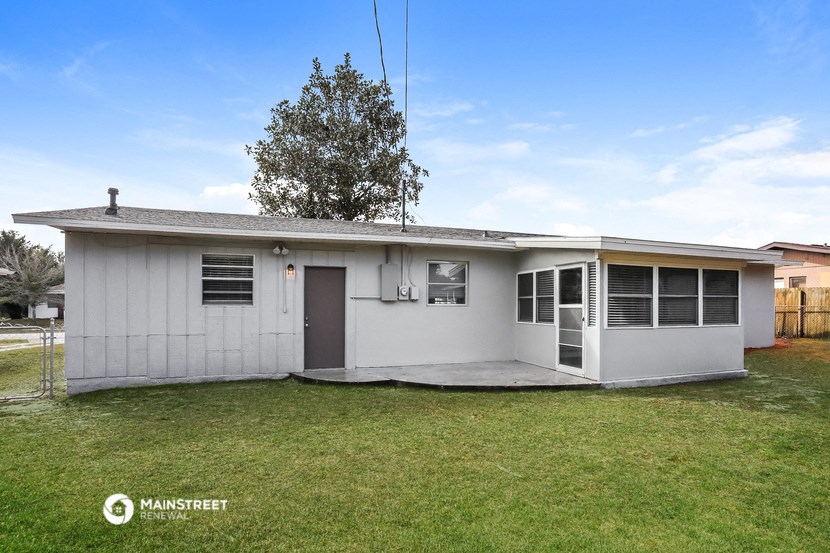a small white house with a yard and a lawn