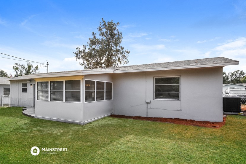 the front of a white house with a grassy yard