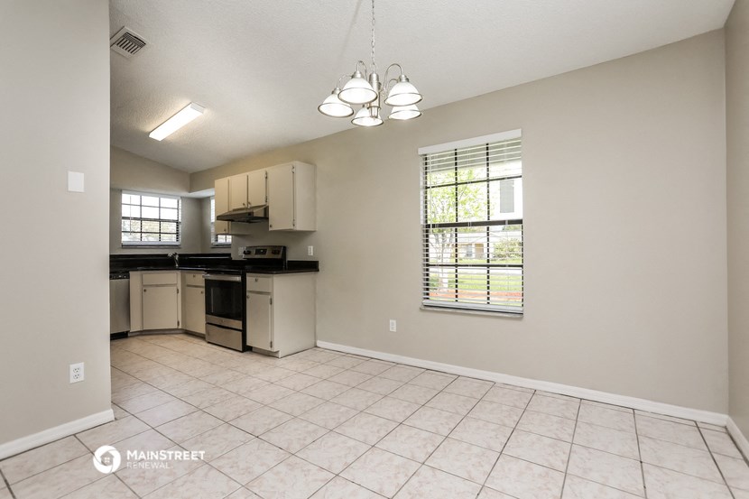 the kitchen and living room are spacious and clean with white appliances and tile flooring