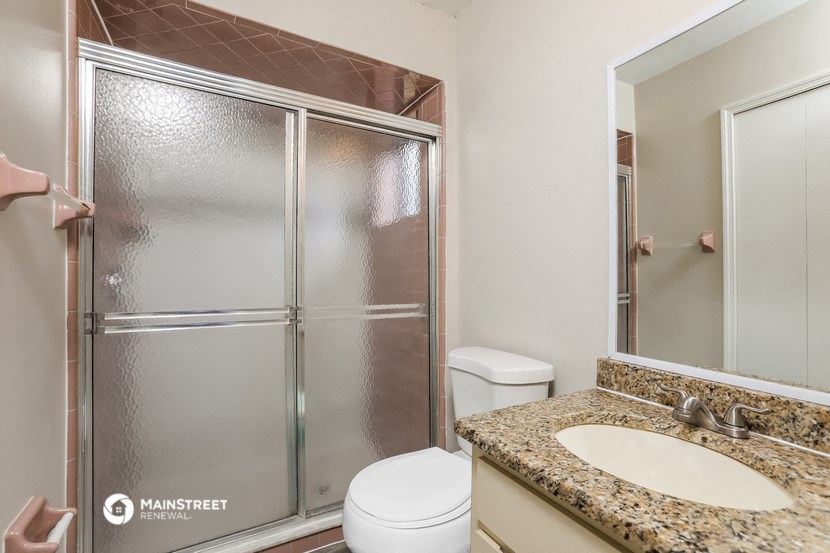 a bathroom with a shower sink and toilet and a mirror