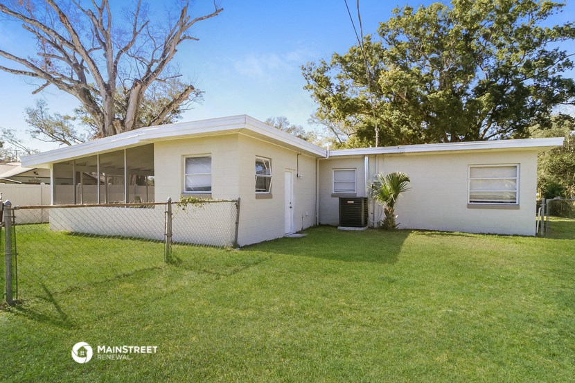 a white house with a yard and a fence