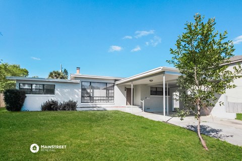 a white house with a lawn and a blue sky