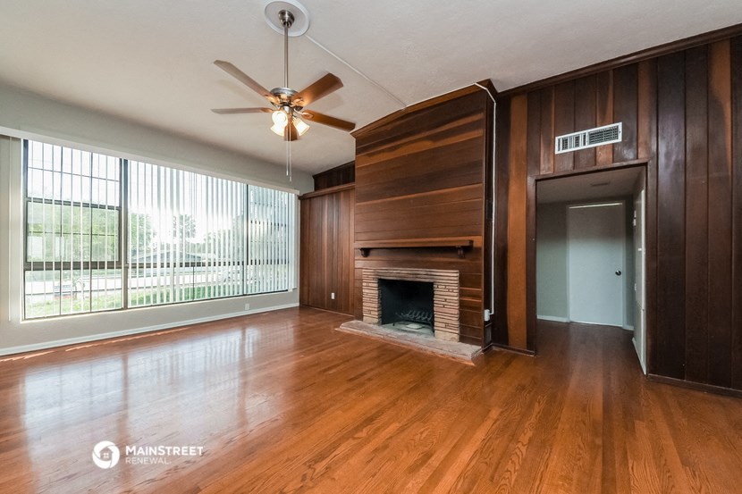 an empty living room with wood floors and a fireplace