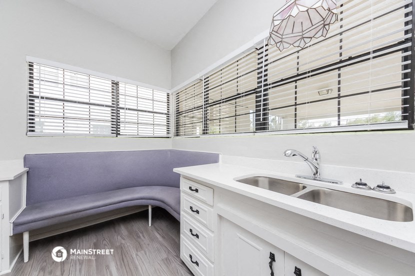 a kitchen with a sink and a purple couch