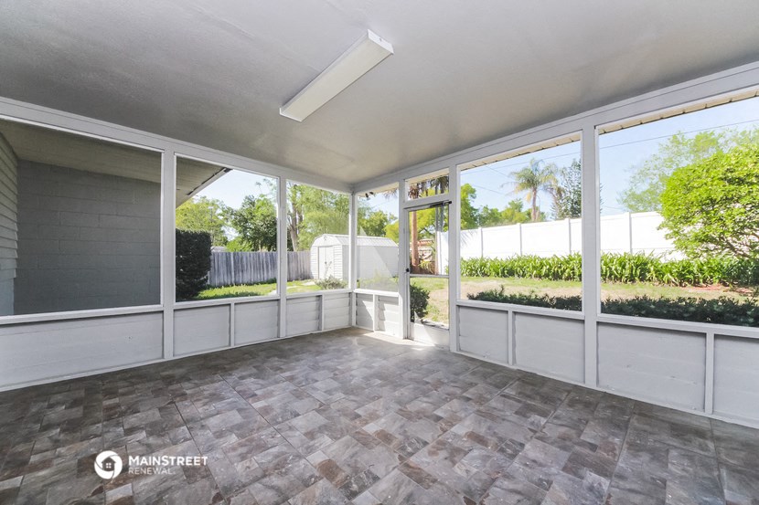 an empty living room with large windows and a patio