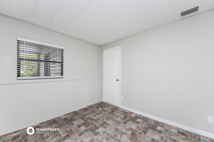 the living room of a manufactured home with white walls and a window
