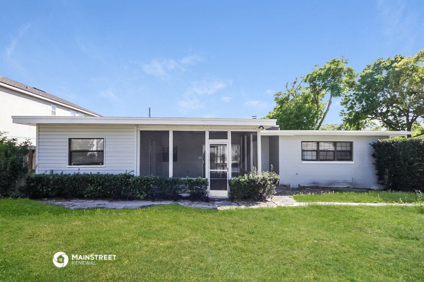 a small white house with a lawn and a door