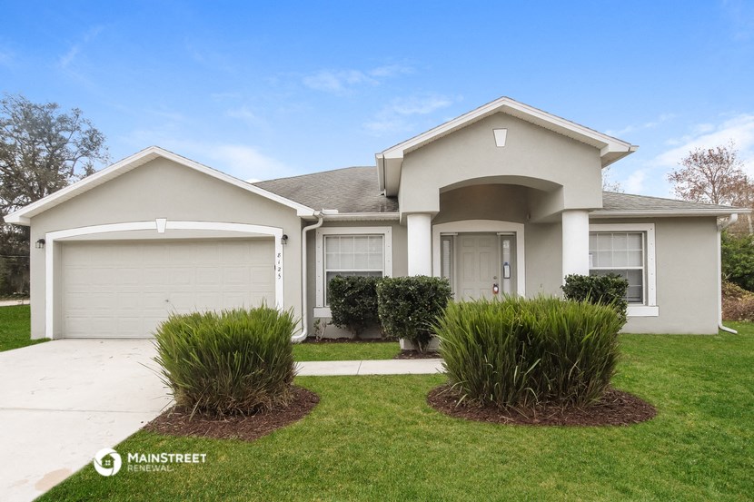 a white house with a lawn and a driveway