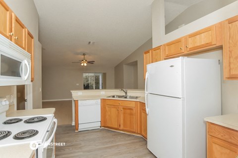 a kitchen with white appliances and wooden cabinets