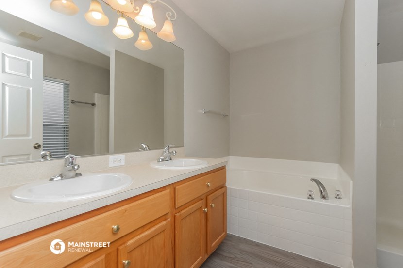 a bathroom with two sinks and a tub and a mirror