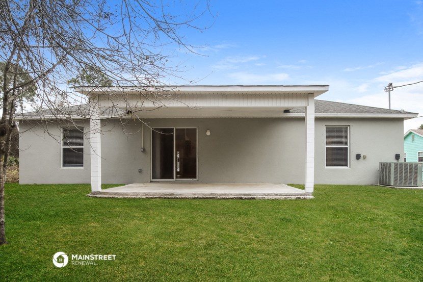 a small white house with a lawn and a porch