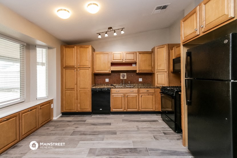 a kitchen with wooden cabinets and black appliances