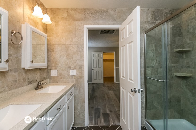 a bathroom with a shower and a sink and a mirror
