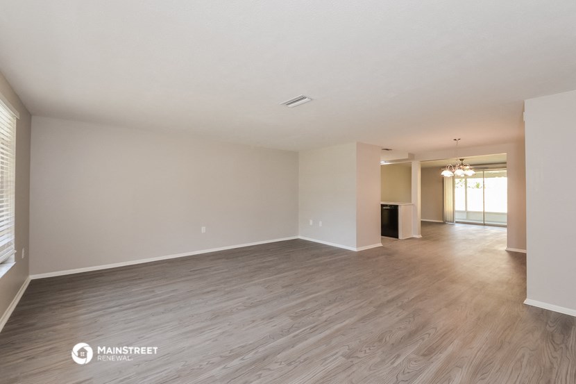 the spacious living room and dining room with wood flooring