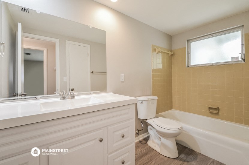 a bathroom with a toilet and a sink and a bath tub