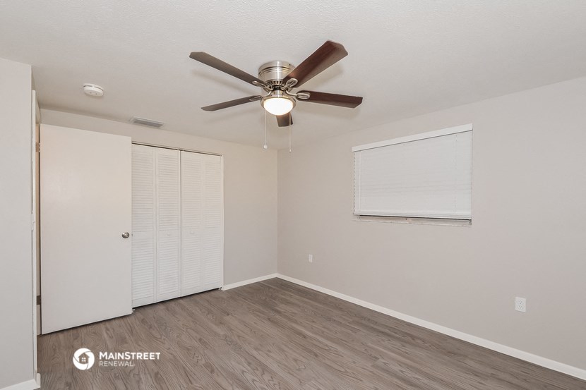 the living room of our studio apartment atrium with ceiling fan and closet