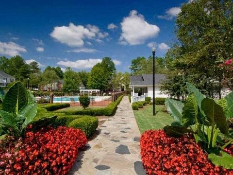 A garden pathway with red flowers on either side.