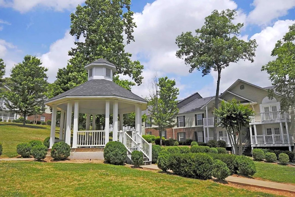 A gazebo is in the front of a row of houses.