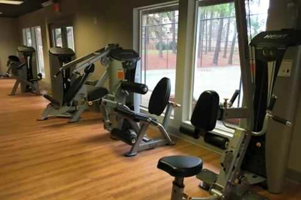 A gym with a row of exercise machines.