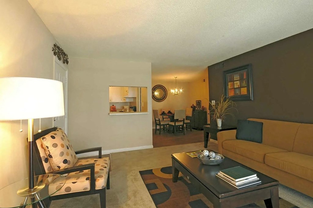 A living room with a yellow couch and a coffee table.