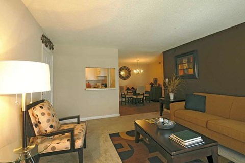 A living room with a yellow couch and a coffee table.
