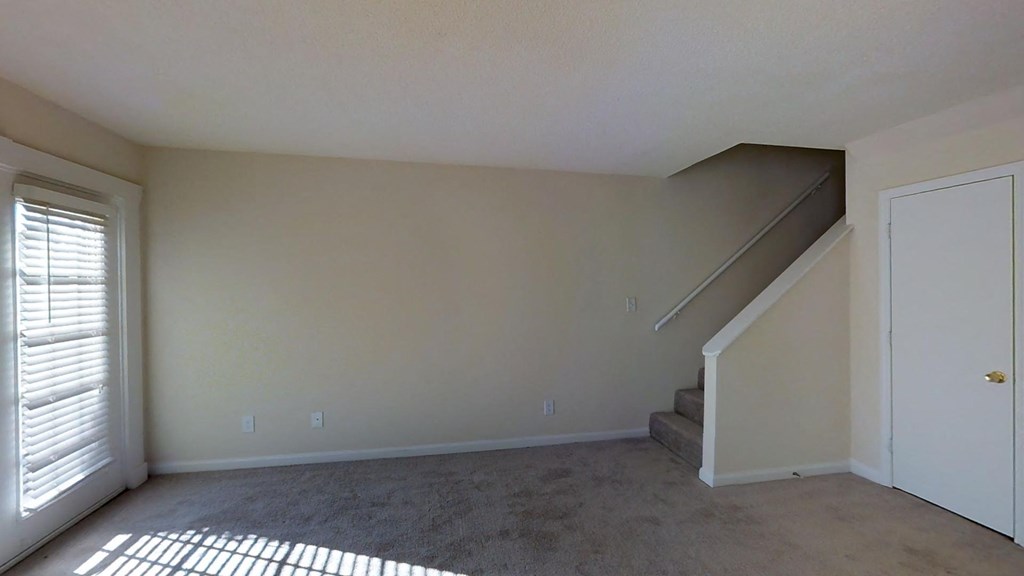 A room with a staircase and a door.