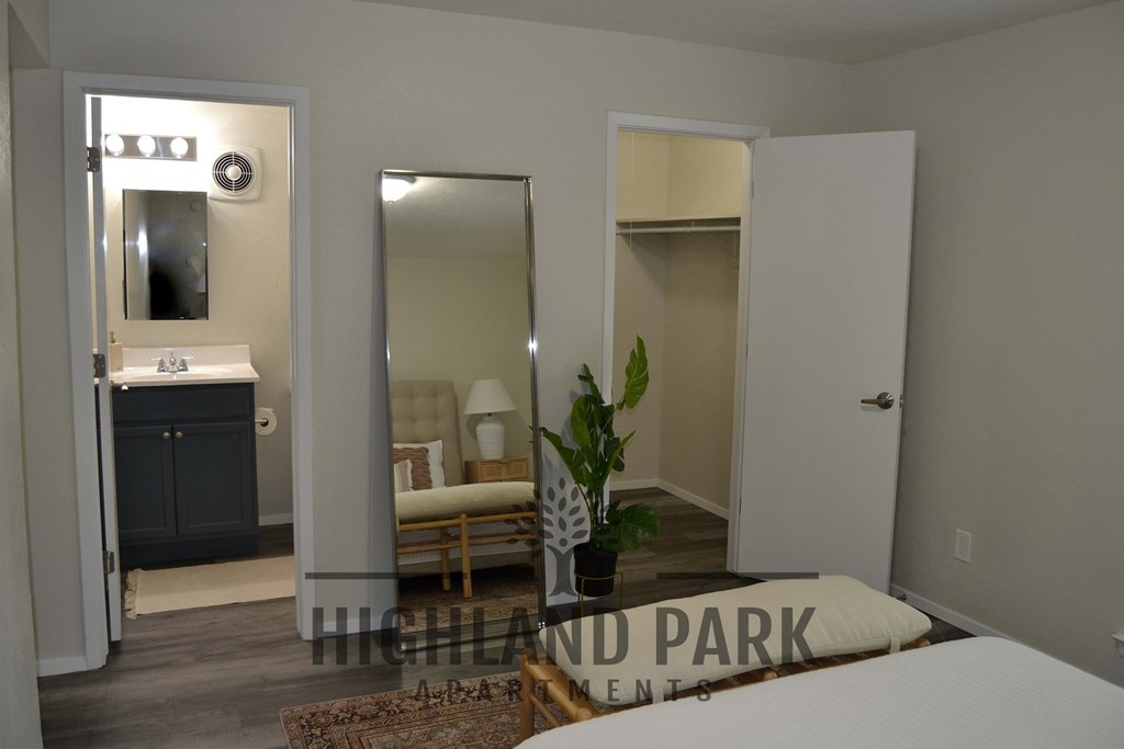 a bedroom with a bed and a bathroom with a sink and mirrors