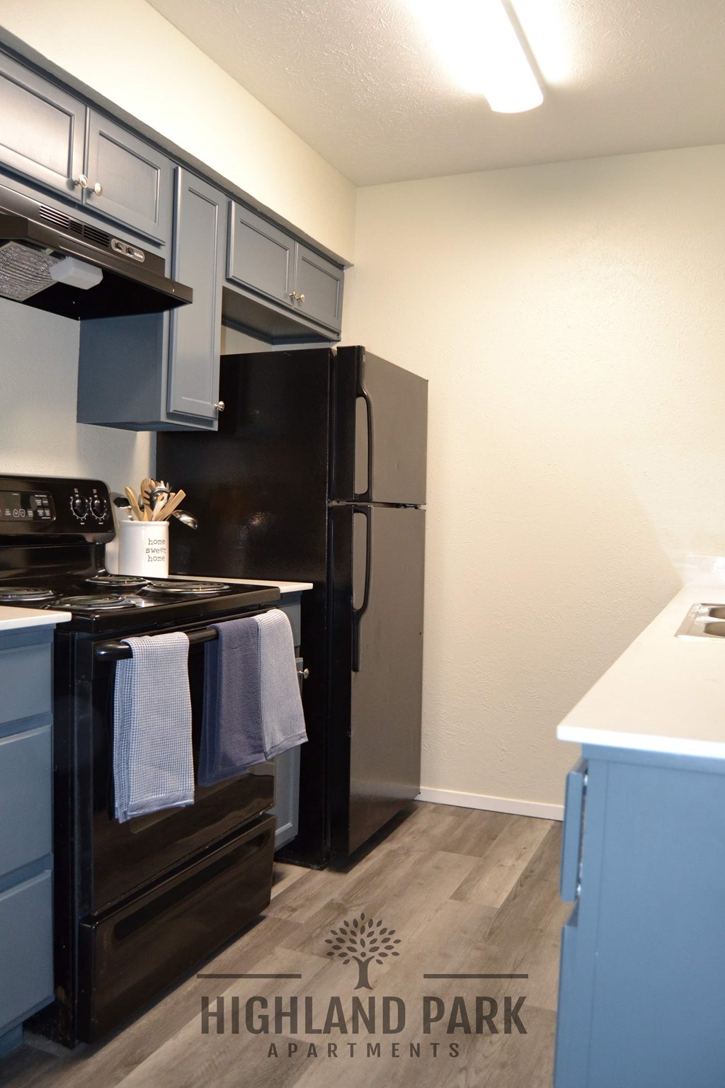a kitchen with blue cabinets and a black refrigerator