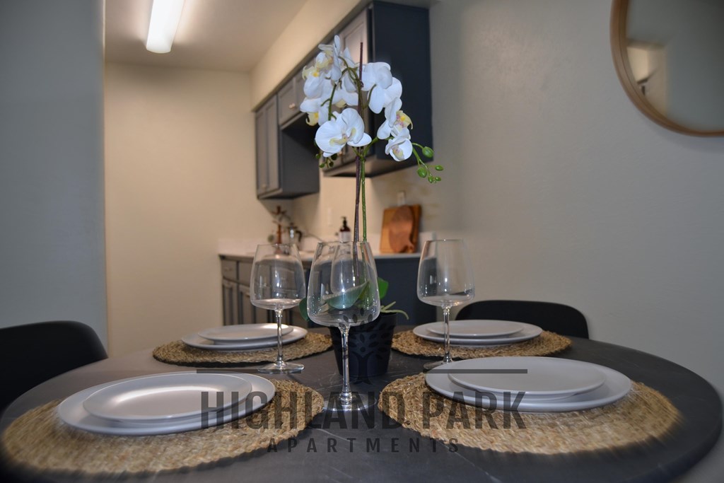 a dining table with plates and wine glasses in a living room