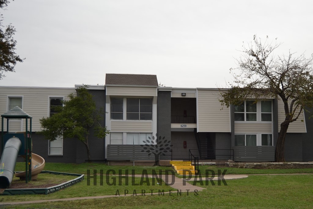 an apartment building with a playground in front of it