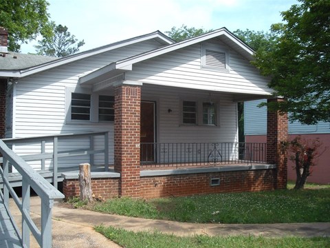 a white house with a porch and a white fence