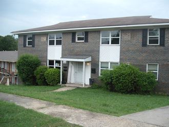 a brick house with a lawn in front of it