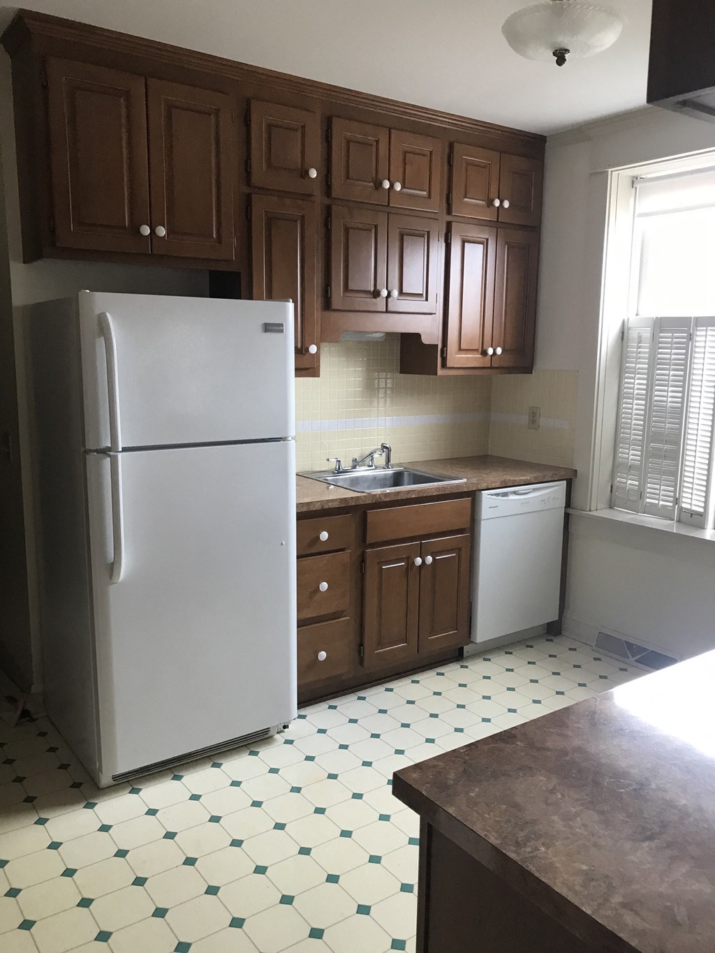 an empty kitchen with a refrigerator and a sink