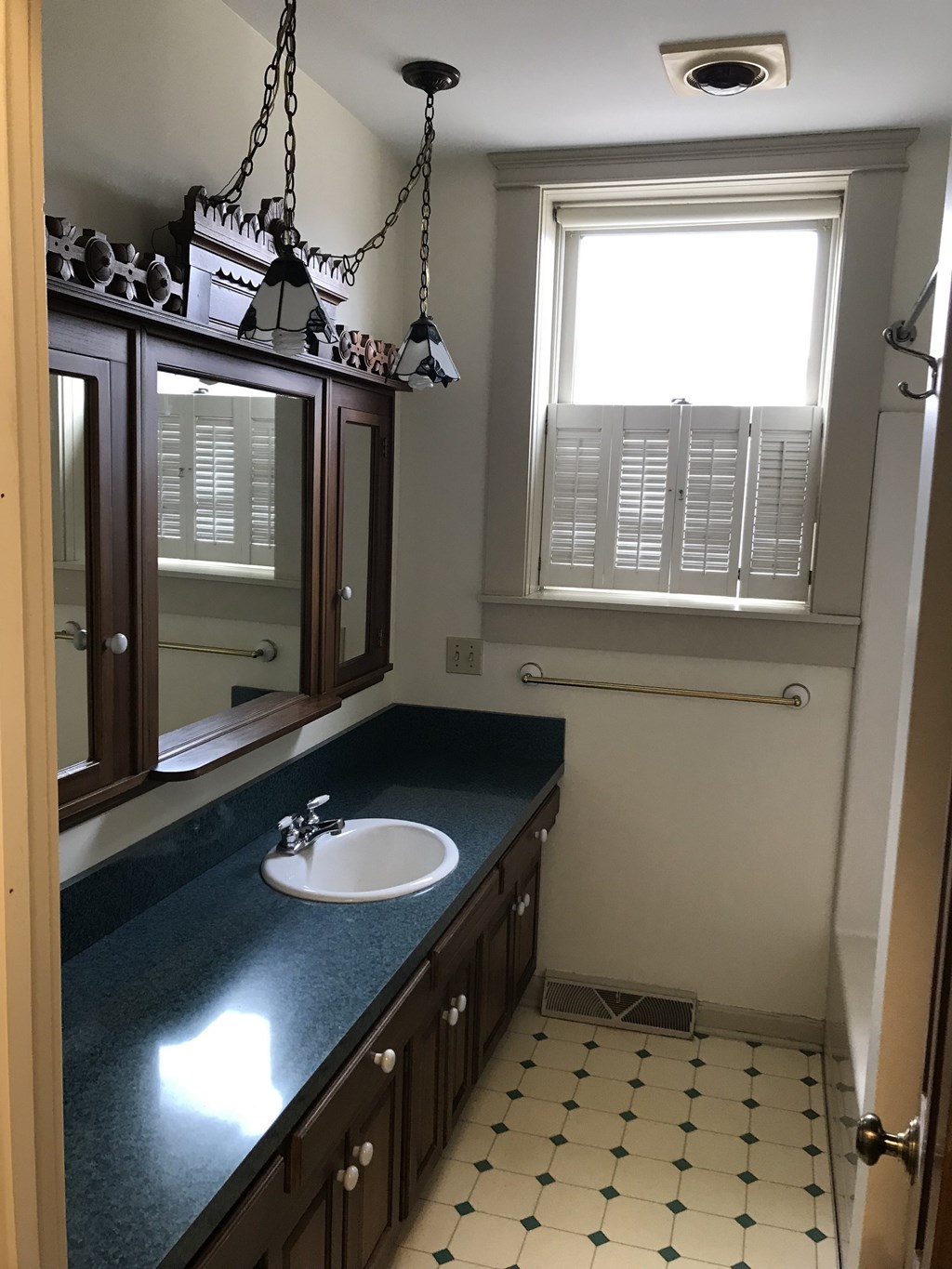 a bathroom with a sink and a mirror and a window