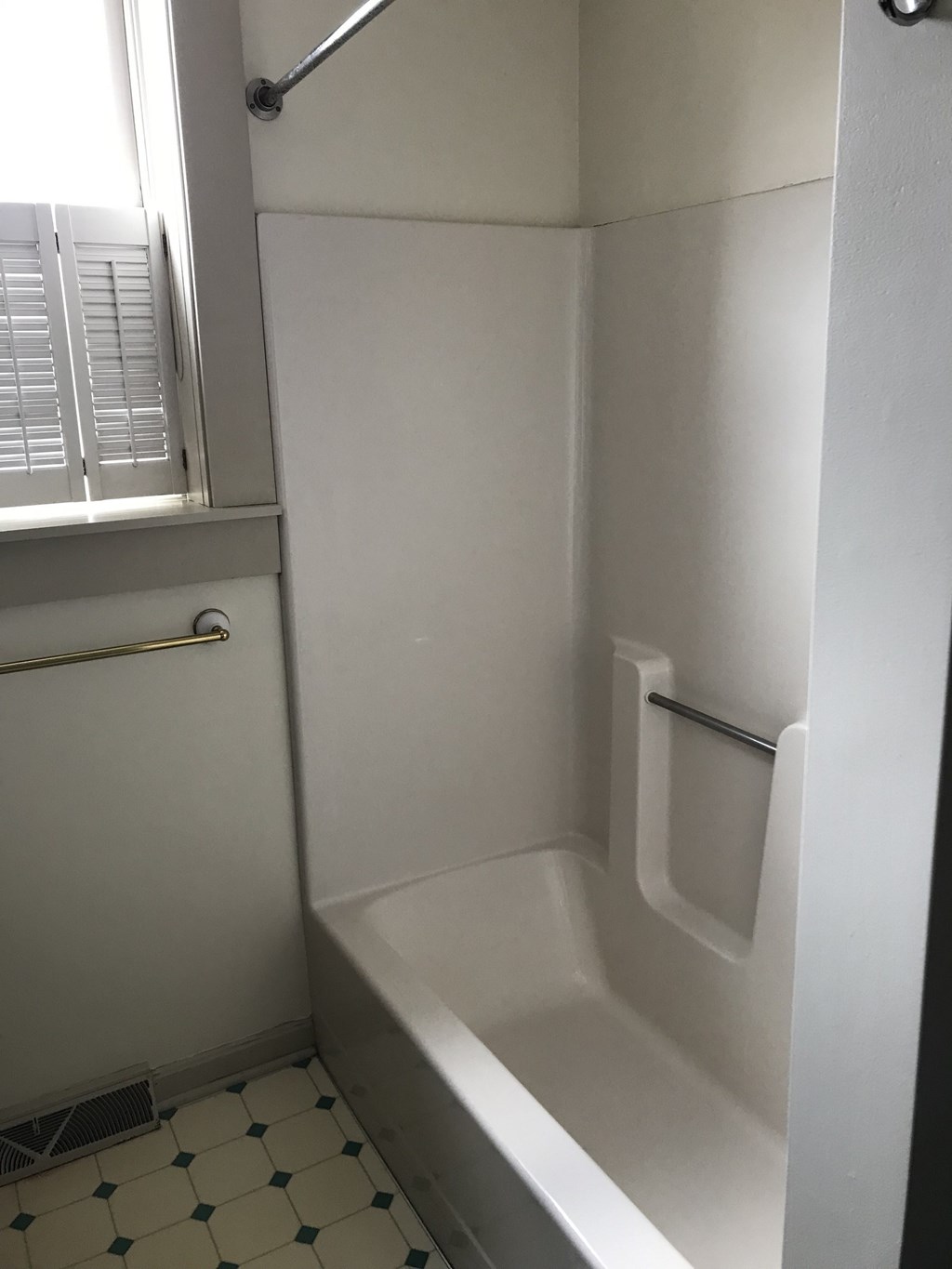 a small bathroom with a tub and a window