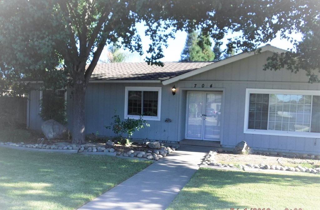 a white house with a tree in the front yard