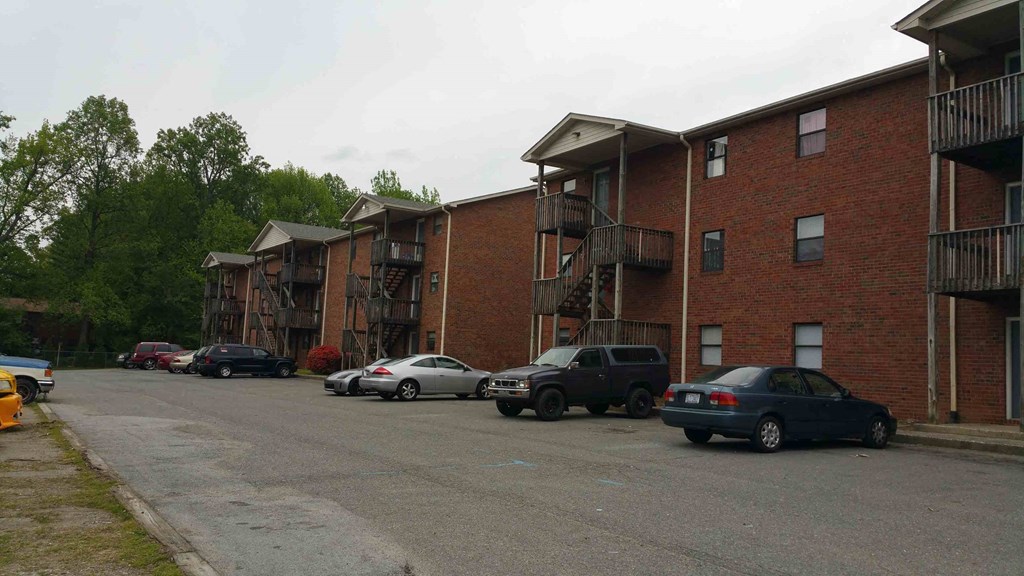 an empty parking lot in front of an apartment building