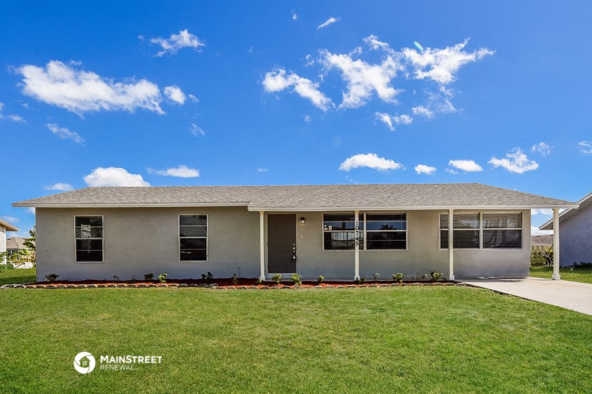 a white house with a lawn and a blue sky