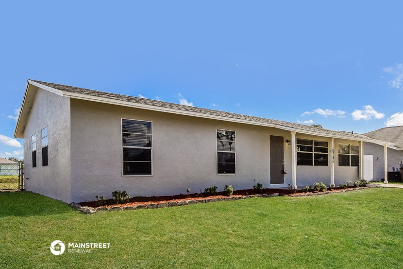 a white house with a lawn and a blue sky
