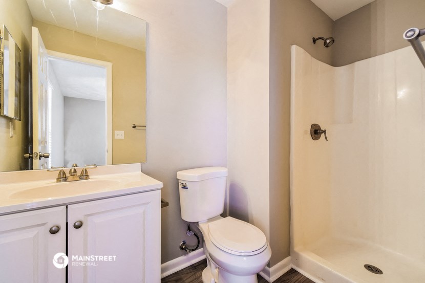 a bathroom with a toilet and a shower and a sink