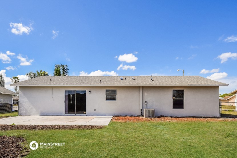 a white house with a grassy yard and a blue sky